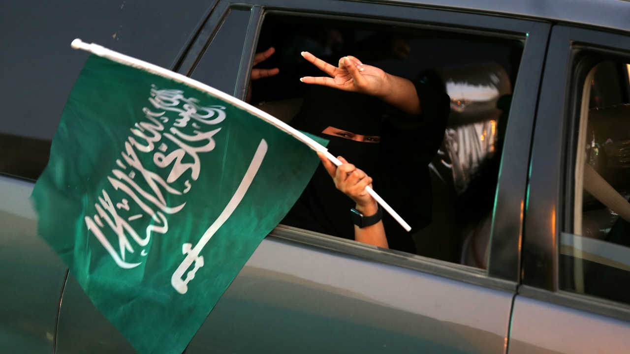 فتاة تحمل علم السعودية