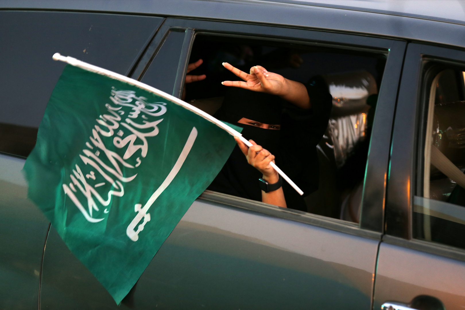 فتاة ترفع علم السعودية
